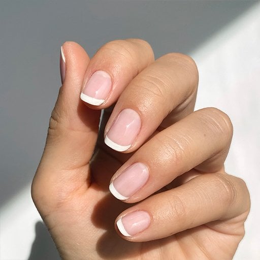 Hand with short french tip manicure