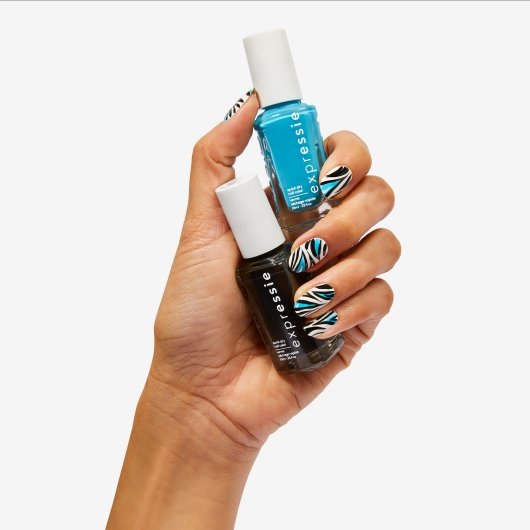 medium skin hand with zebra print nail art holding black and blue nail polish bottles