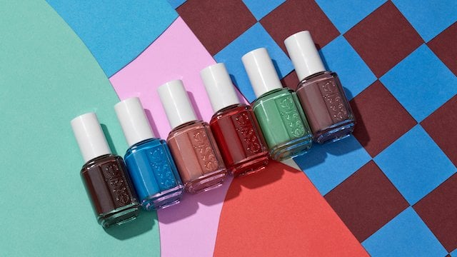 6 bottles of essie nail polish from the odd squad collection laid on a brightly colored surface