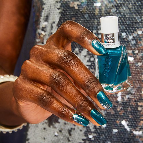 woman in silver sequined dress with glitter confetti nail art holding essie nail polish
