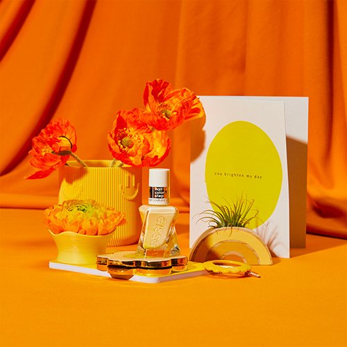 essie lemon nail polish with orange and yellow flowers and bright yellow decorations