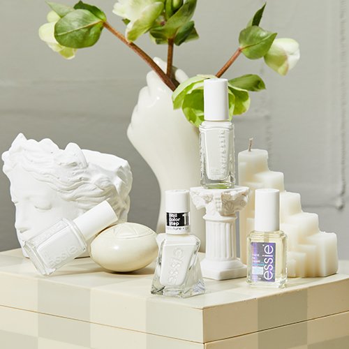 essie white nail polish collection with white and off-white accessories on pale box