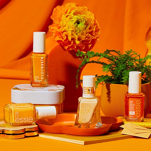 bottles of yellow essie nail polish shades with plant, flower, and decor