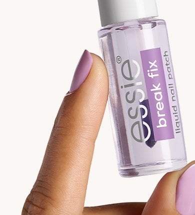 Essie Break Fix bottle held by hand painted in lavender nail polish