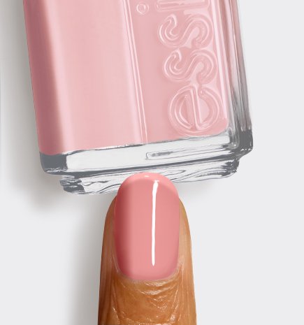 Close-up of a single fingernail painted in a"Cheeky Jelly", positioned below a matching bottle of essie polish.