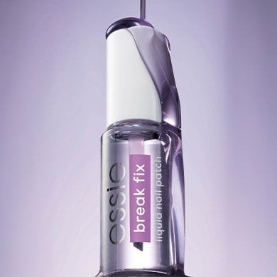 Essie Break Fix bottle on lavender background with polish being poured on top of it