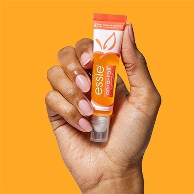  A hand holds a bottle of cuticule care product.