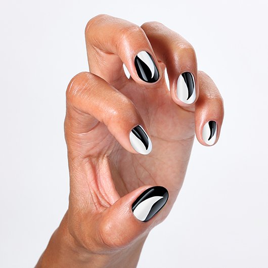 hand featuring a black and white halloween nail art design inspired by cat nails