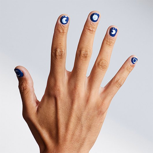 outstretched hand with short nails, each featuring nail art of different moon cycles on a blue base