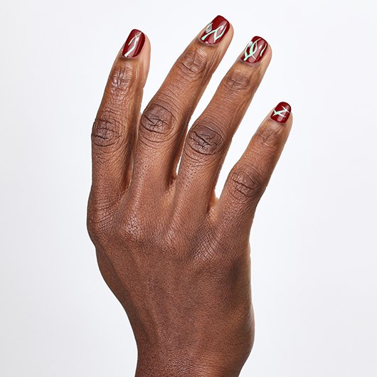 hand with botanical nail art featuring a red nail polish base with green vine-like details