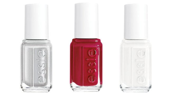 Three Essie nail polish bottles are displayed side by side. The colors are silver, deep red, and white, each with a sleek, glossy finish.