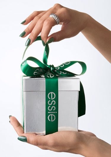 Hands holding a gift box with a green ribbon. 