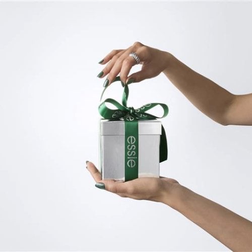 Hands holding a gift box with a green ribbon. 