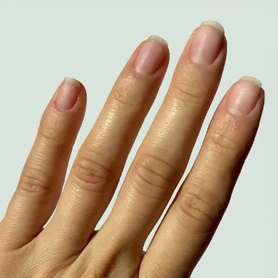 nude nails without any products on a light skin hand with fingers pointing upward