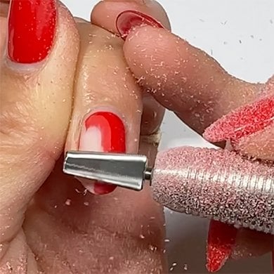 one finger on a light skin hand with the middle nail being filed