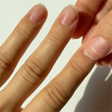 three fingers on a light skin hand with the other hand rubbing the index fingernail