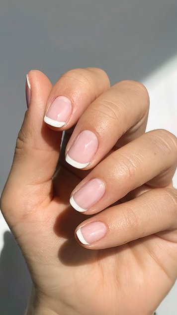 Hand with short french tip manicure