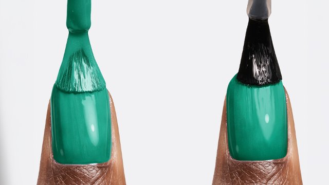 Dark skin thumbs side by side, one being brushed with green gel polish, the other with shiny gel finish