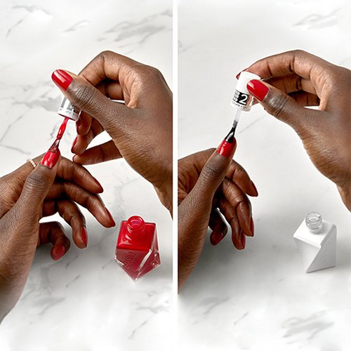 Model painting their thumb nail with red essie gel couture nail polish and a clear top coat