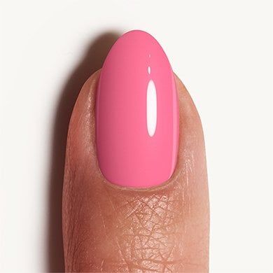 Light skin fingernail on white background wearing bright pink Haute To Trot essie nail polish