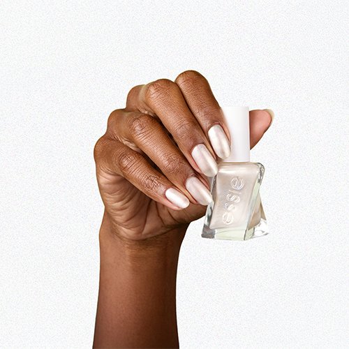 dark skin hand on a white background wearing and holding a bottle of pearly white essie nail polish