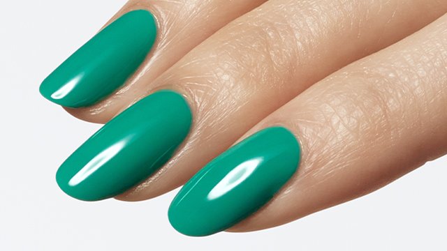 closeup of three nails on light skin hand wearing gel by essie in green with a shiny finish.