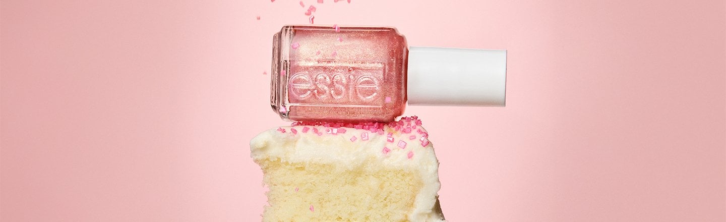 sprinkles raining down on a bottle of pink nail polish on top of a piece of cake on a fork