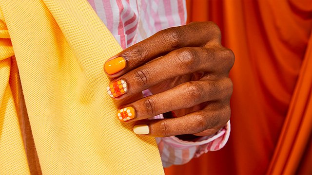 woman with multi color yellow polka dot nail polish design