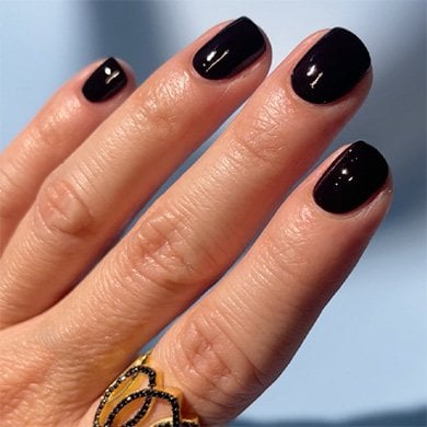 fair-skinned hand with black painted nails