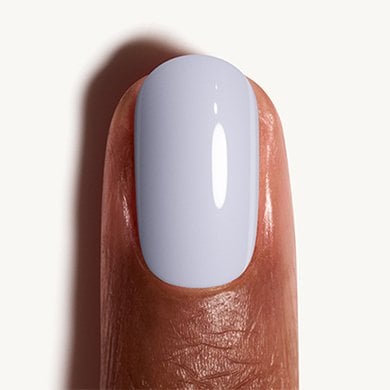 Closeup of a dark skin fingertip painted in pastel blue nail polish Bikini So Teeny